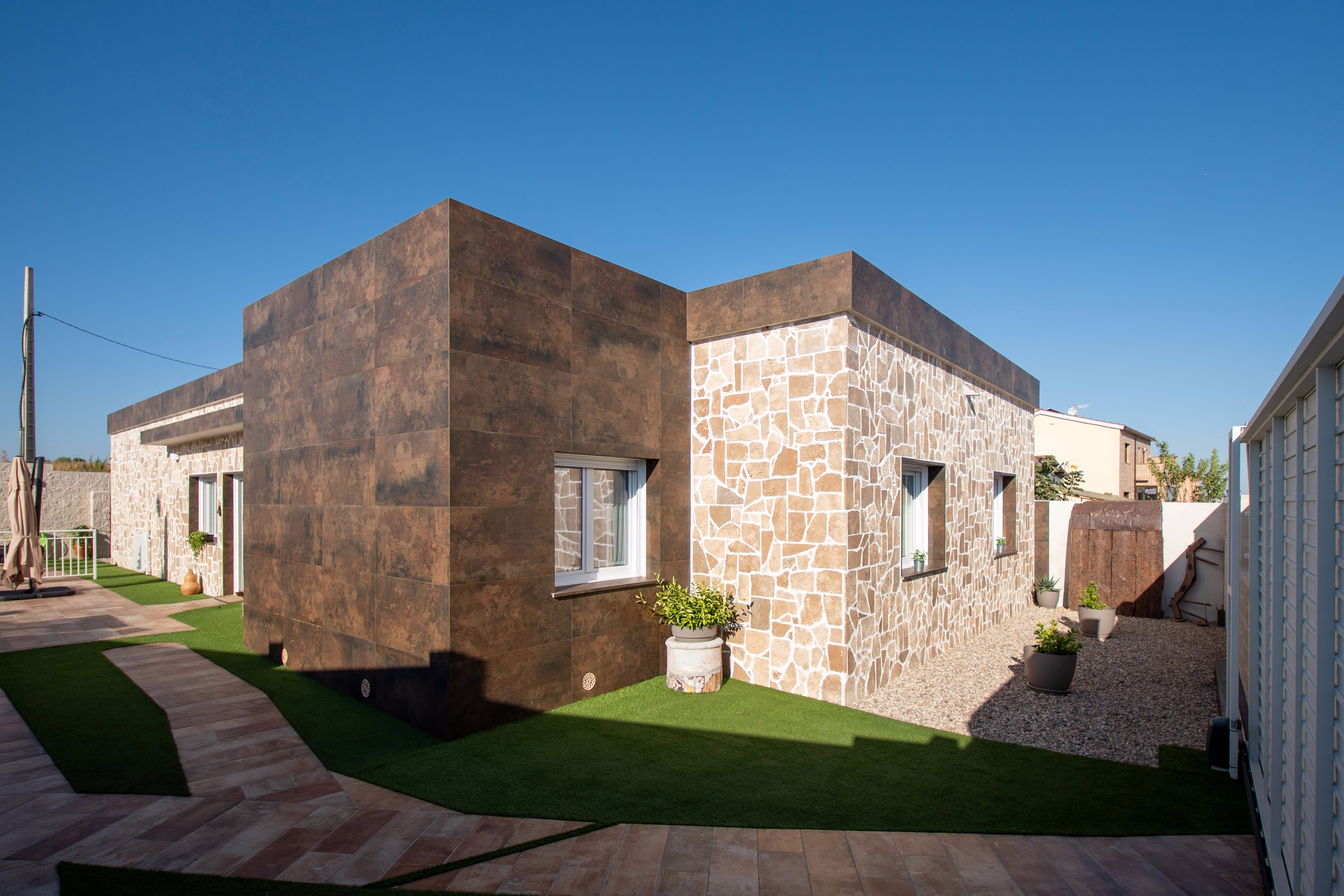 Fachada edificio con detalles cuidados y camino de acceso